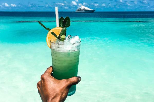 Cocktail aux Maldives avec yacht en arrière plan 
